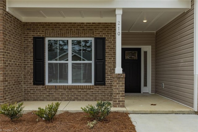 view of exterior entry featuring brick siding