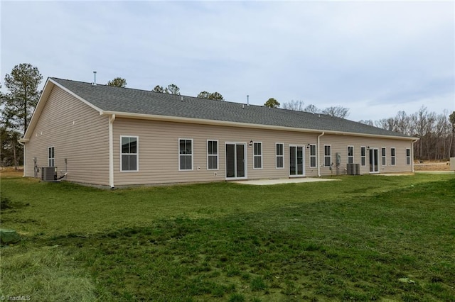 back of house with central AC unit, a lawn, and a patio