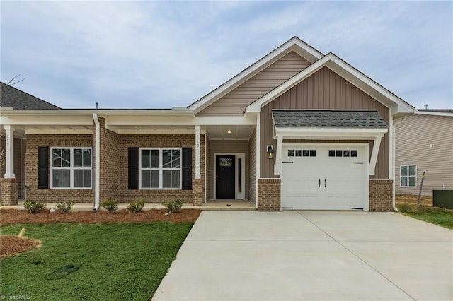 craftsman inspired home with an attached garage, concrete driveway, brick siding, a front lawn, and board and batten siding