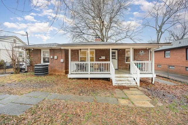 ranch-style house with a porch and central air condition unit