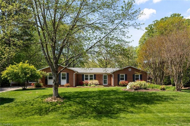 single story home with a front lawn and brick siding