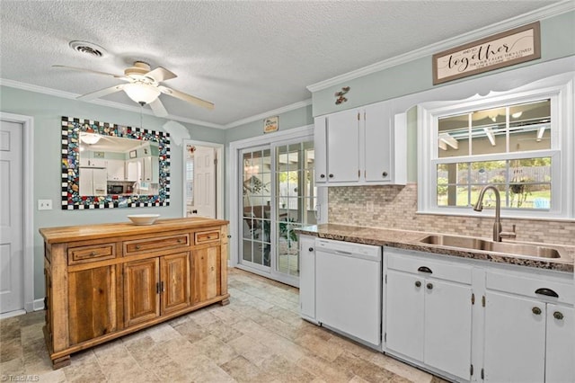 kitchen with white dishwasher, a sink, a ceiling fan, ornamental molding, and white cabinetry