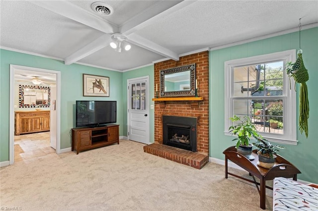 living room with a ceiling fan, carpet flooring, a fireplace, beamed ceiling, and a textured ceiling