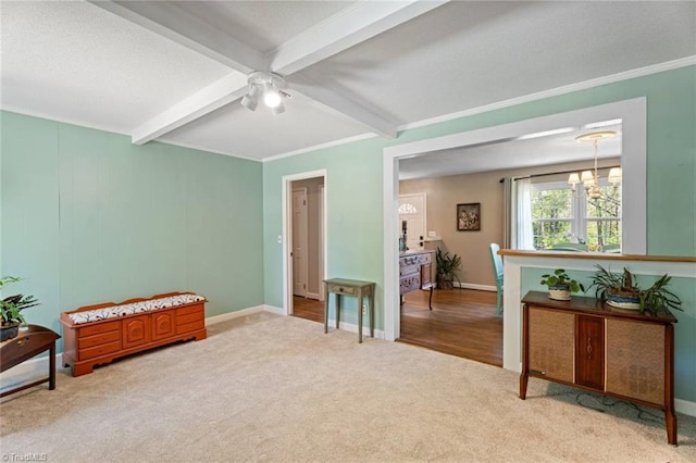 living area with light colored carpet, beam ceiling, a ceiling fan, baseboards, and ornamental molding