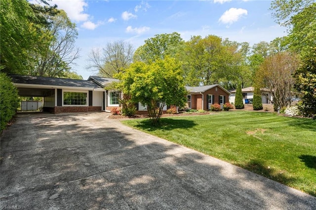 ranch-style home featuring concrete driveway, brick siding, and a front lawn