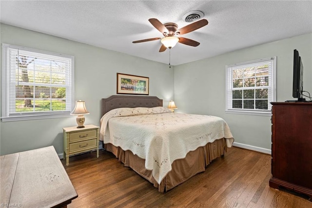 bedroom featuring dark wood-style floors, baseboards, a textured ceiling, and a ceiling fan