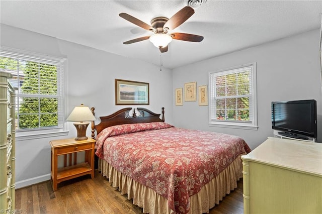bedroom with wood finished floors, baseboards, and a ceiling fan