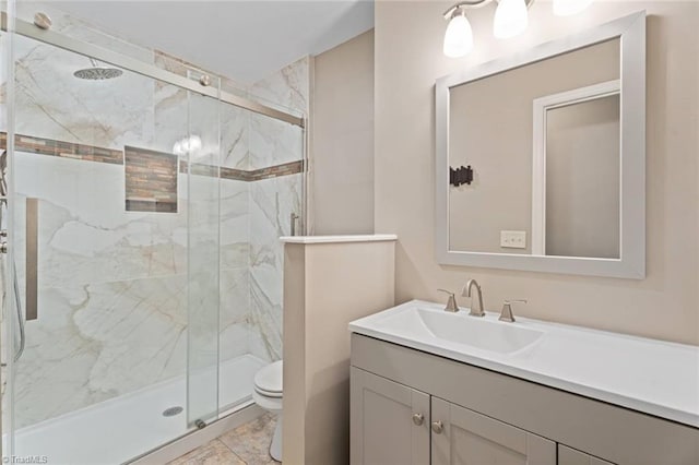 full bath with toilet, a marble finish shower, and vanity