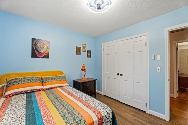 bedroom featuring wood finished floors, baseboards, a closet, and a textured ceiling