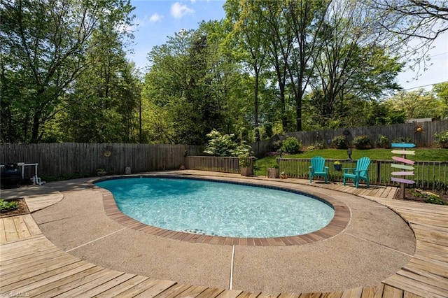 view of swimming pool with a fenced backyard and a deck