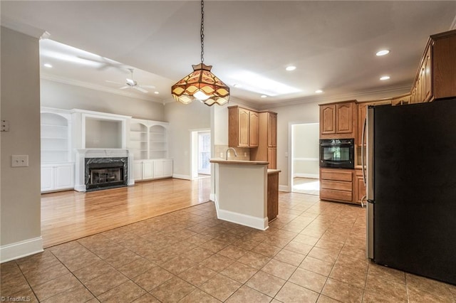 8105 Summit Springs Ct, Browns Summit, NC 27214 - kitchen with freestanding refrigerator, black oven, ornamental molding, open floor plan, and ceiling fan
