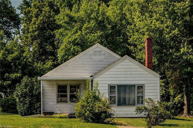 2405 Ellington St, Greensboro, NC 27403 - view of home's exterior featuring a chimney and a lawn