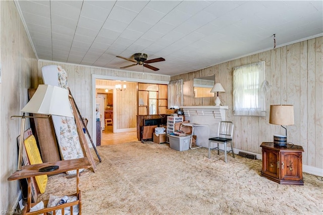 2405 Ellington St, Greensboro, NC 27403 - carpeted living room with a ceiling fan, wooden walls, and ornamental molding