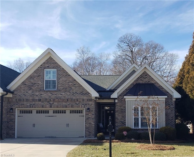 view of front of property with an attached garage, brick siding, driveway, a front lawn, and a standing seam roof