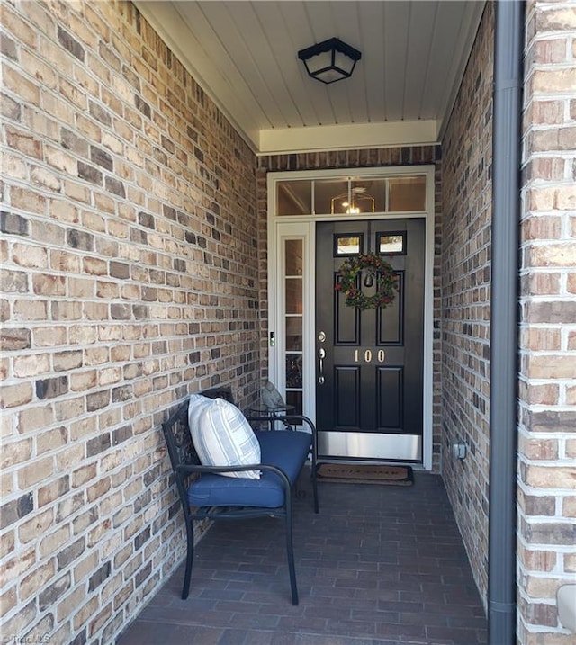 view of exterior entry with brick siding