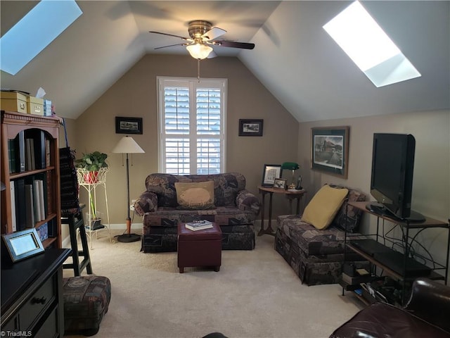 living room with vaulted ceiling with skylight, light colored carpet, and ceiling fan