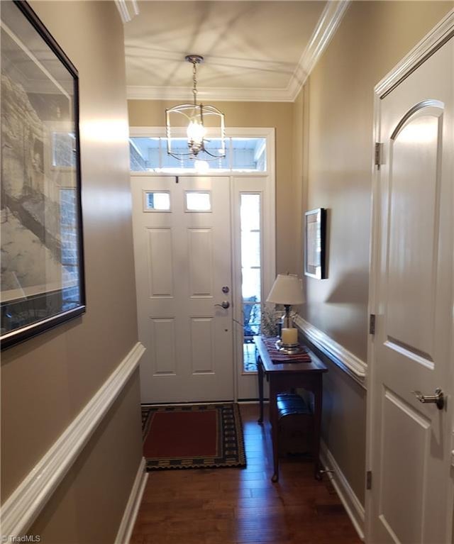 foyer featuring dark wood-style floors, baseboards, ornamental molding, and a chandelier