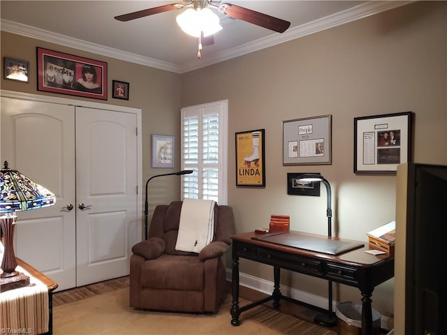 sitting room with ornamental molding, light wood-style flooring, baseboards, and a ceiling fan