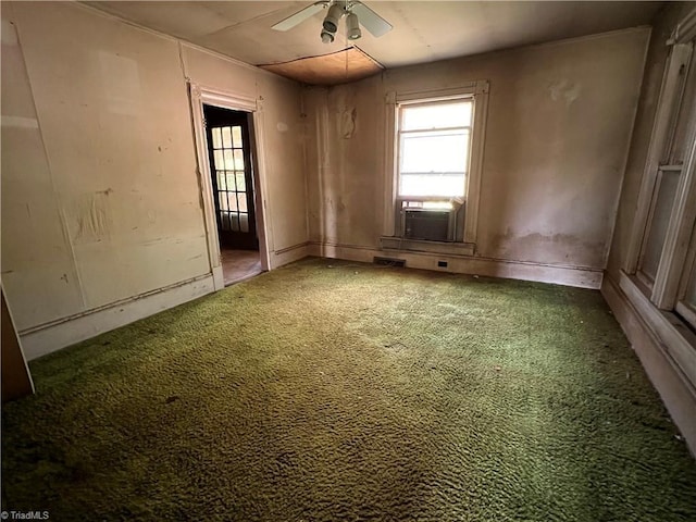 spare room featuring carpet floors, cooling unit, and a ceiling fan