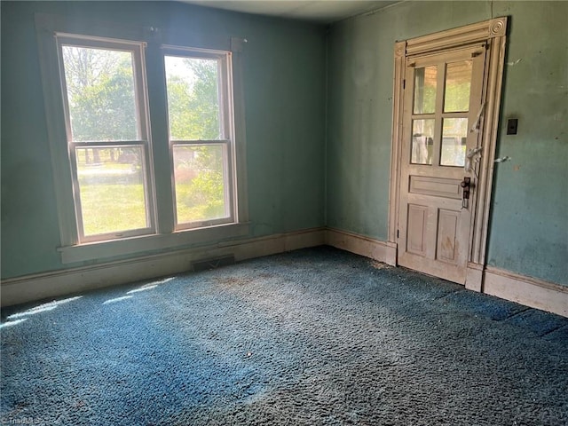 carpeted spare room featuring visible vents and a wealth of natural light