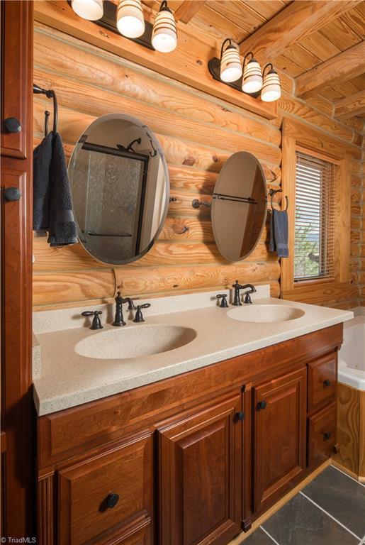 1310 Lynchburg Rd, Westfield, NC 27053 - bathroom with rustic walls, double vanity, wood ceiling, and a sink