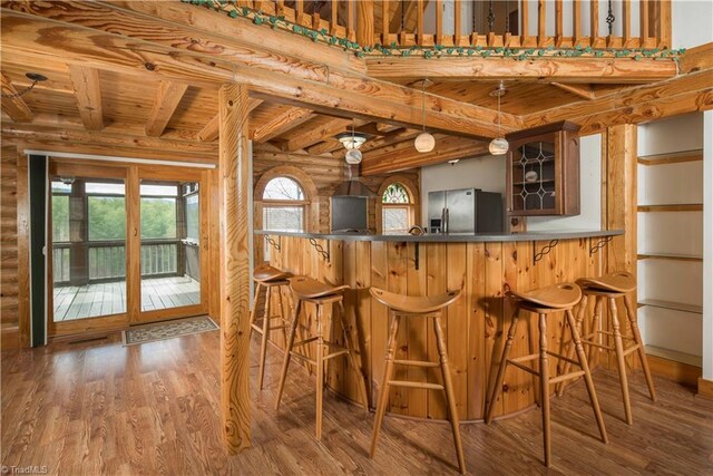 1310 Lynchburg Rd, Westfield, NC 27053 - bar with stainless steel fridge with ice dispenser, beam ceiling, wooden ceiling, wood finished floors, and log walls
