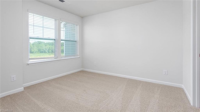 unfurnished room with carpet flooring, visible vents, and baseboards