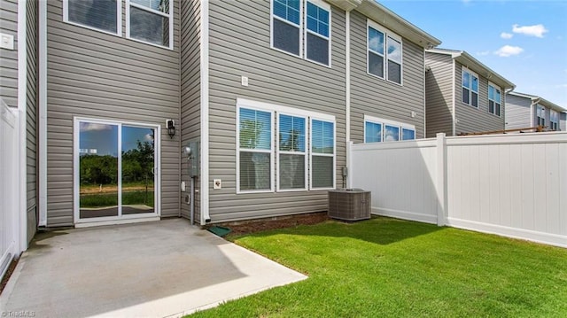 back of property with central AC unit, a yard, a patio area, and fence