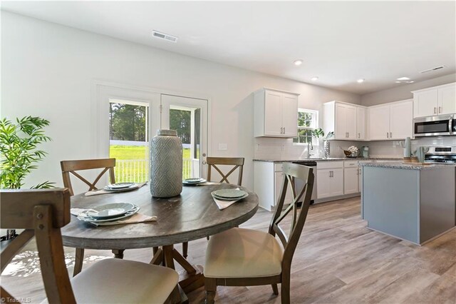 dining room with light wood finished floors, visible vents, and recessed lighting