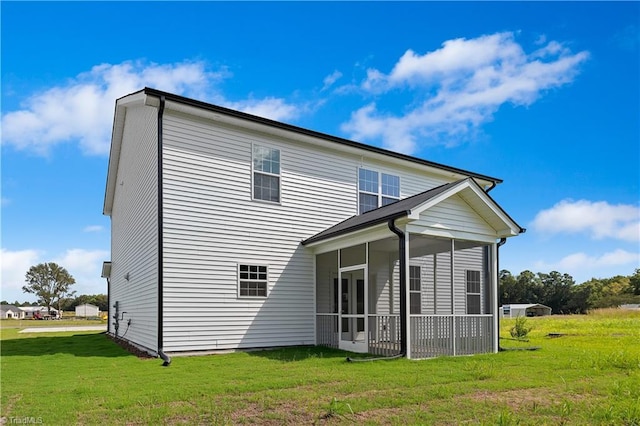 back of property with a lawn and a sunroom