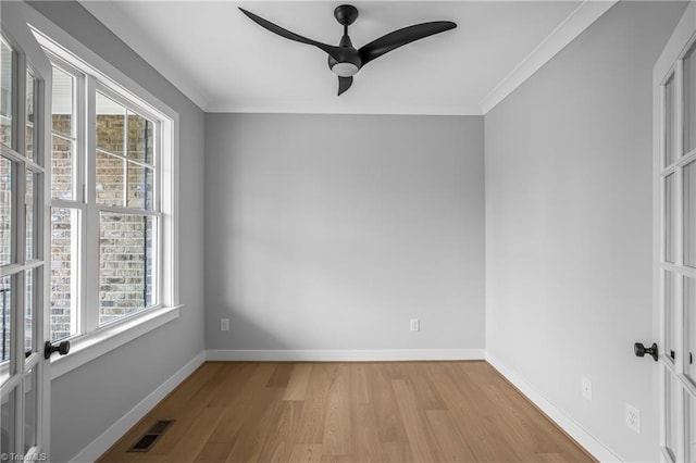 spare room with light wood-style floors, a wealth of natural light, ceiling fan, and visible vents