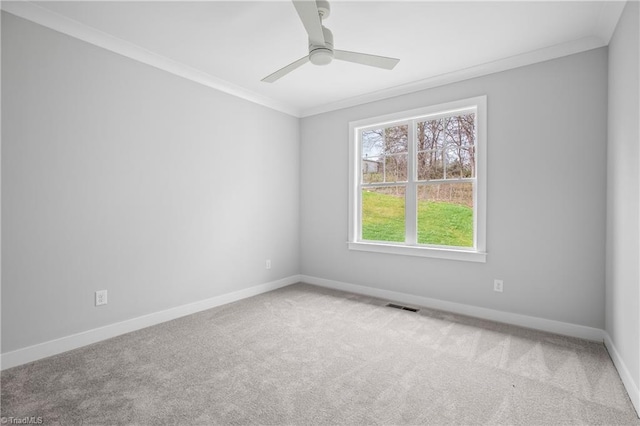 spare room with crown molding, baseboards, visible vents, and carpet