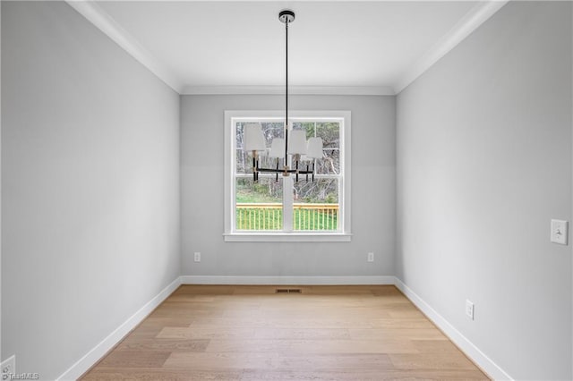 unfurnished dining area featuring light wood-style floors, baseboards, crown molding, and visible vents