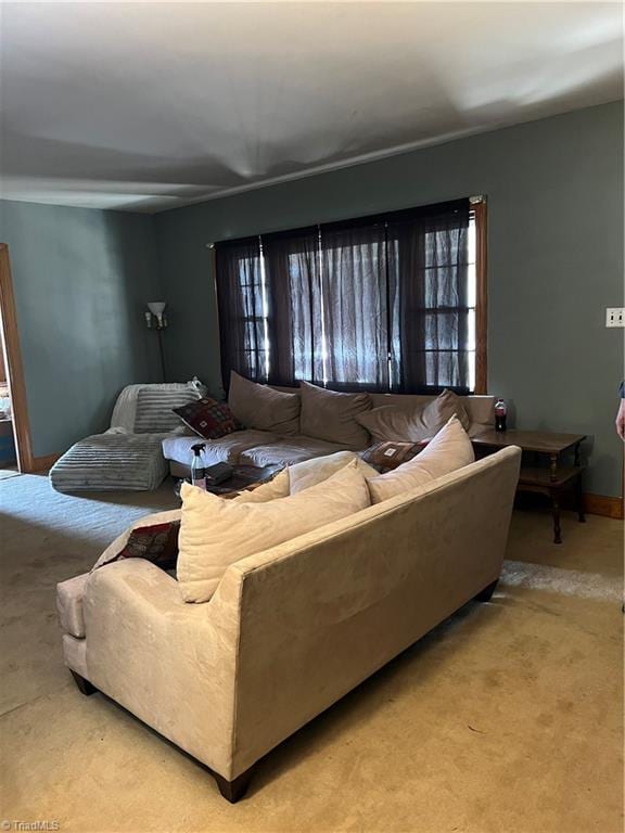 carpeted living area featuring baseboards