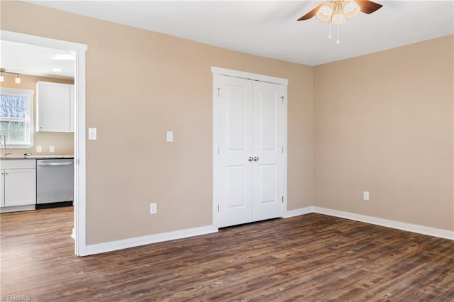 unfurnished bedroom featuring a closet, baseboards, and dark wood-style flooring