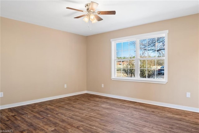 spare room with ceiling fan, baseboards, and dark wood-style flooring