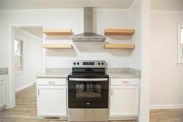 kitchen featuring stainless steel range with electric stovetop, white cabinetry, light stone countertops, and wall chimney range hood