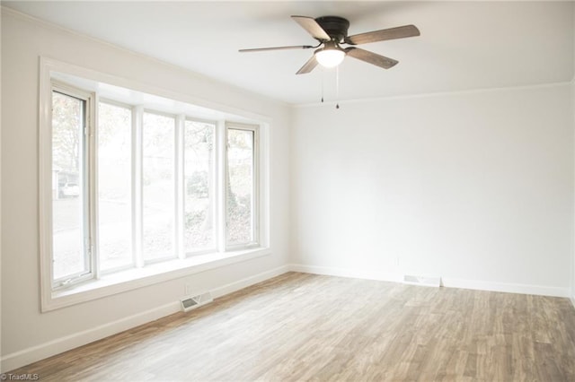 spare room featuring plenty of natural light, ceiling fan, and wood-type flooring