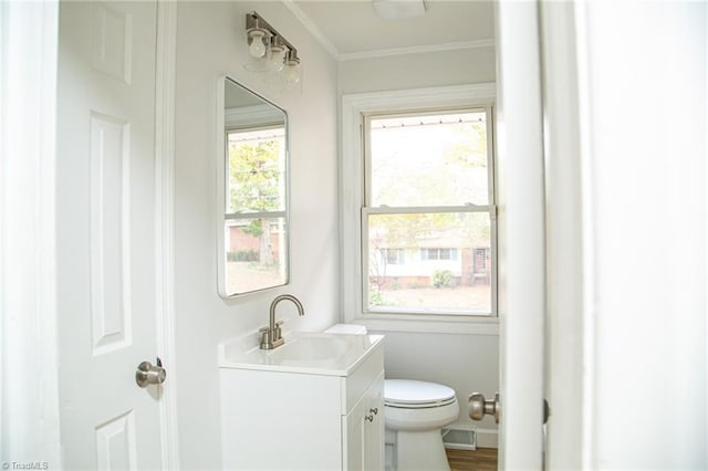 bathroom with a wealth of natural light, vanity, hardwood / wood-style flooring, and toilet