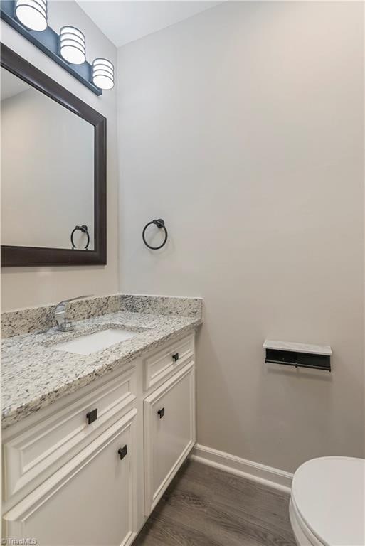 bathroom featuring hardwood / wood-style floors, vanity, and toilet