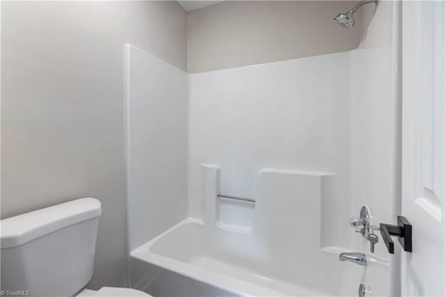 bathroom with washtub / shower combination and toilet