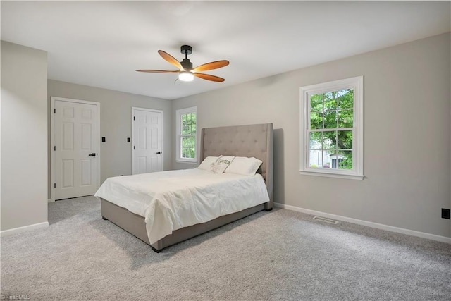 carpeted bedroom with baseboards, visible vents, and a ceiling fan