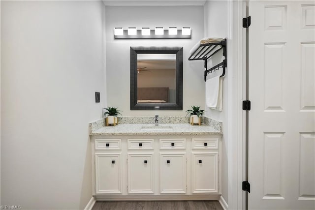 bathroom featuring wood finished floors, vanity, and baseboards
