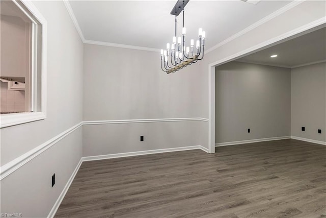 spare room featuring ornamental molding, a chandelier, and dark hardwood / wood-style flooring