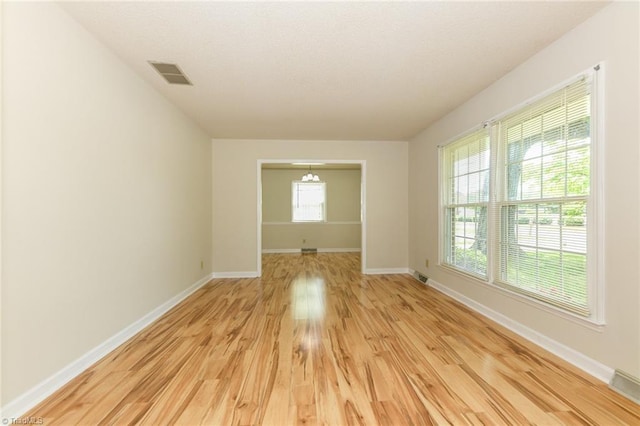 spare room featuring light wood-type flooring and baseboards