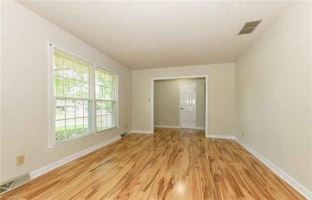 unfurnished room with light wood finished floors and baseboards