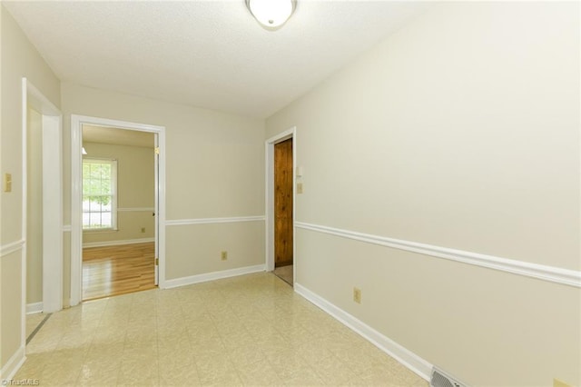 empty room featuring baseboards and light floors