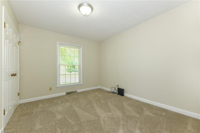 carpeted spare room featuring baseboards