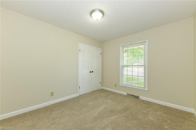 empty room with light colored carpet and baseboards