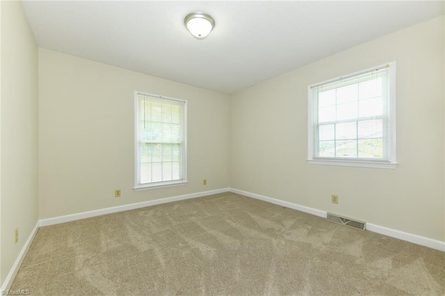 unfurnished room with carpet flooring, healthy amount of natural light, and baseboards